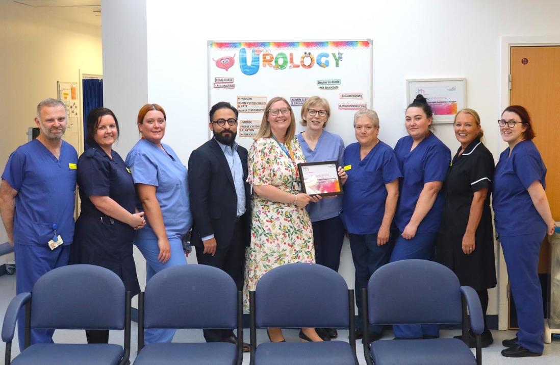 Mr Syed Ali Shahzad with a urology team holding a team recognition award
