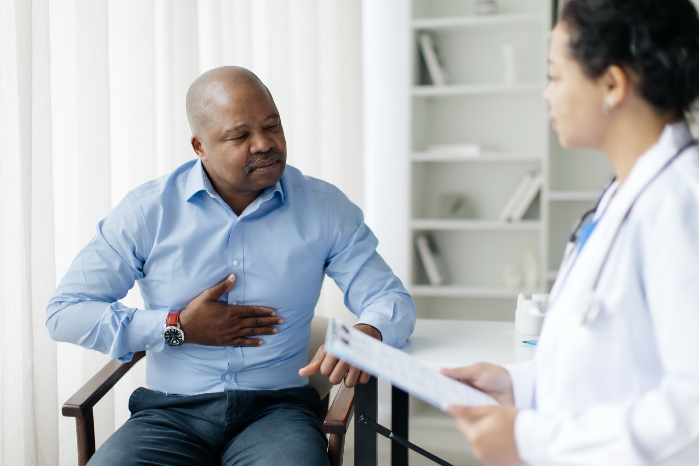 Patient discussing symptoms with a doctor during a clinic consultation